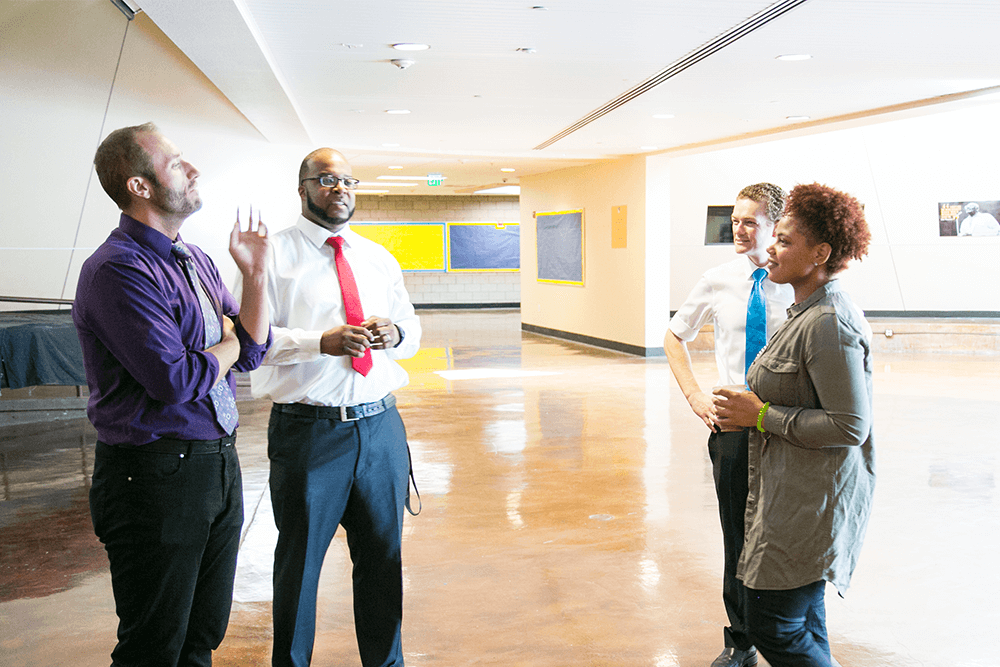 group of business people chatting in a work place hallway