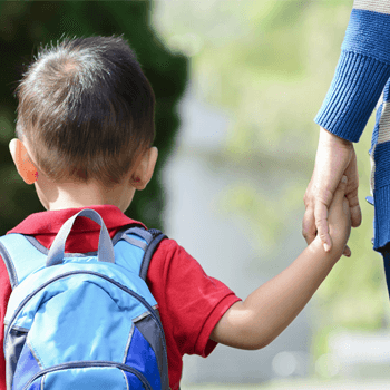 preschool aged child walking while holding a woman's hand