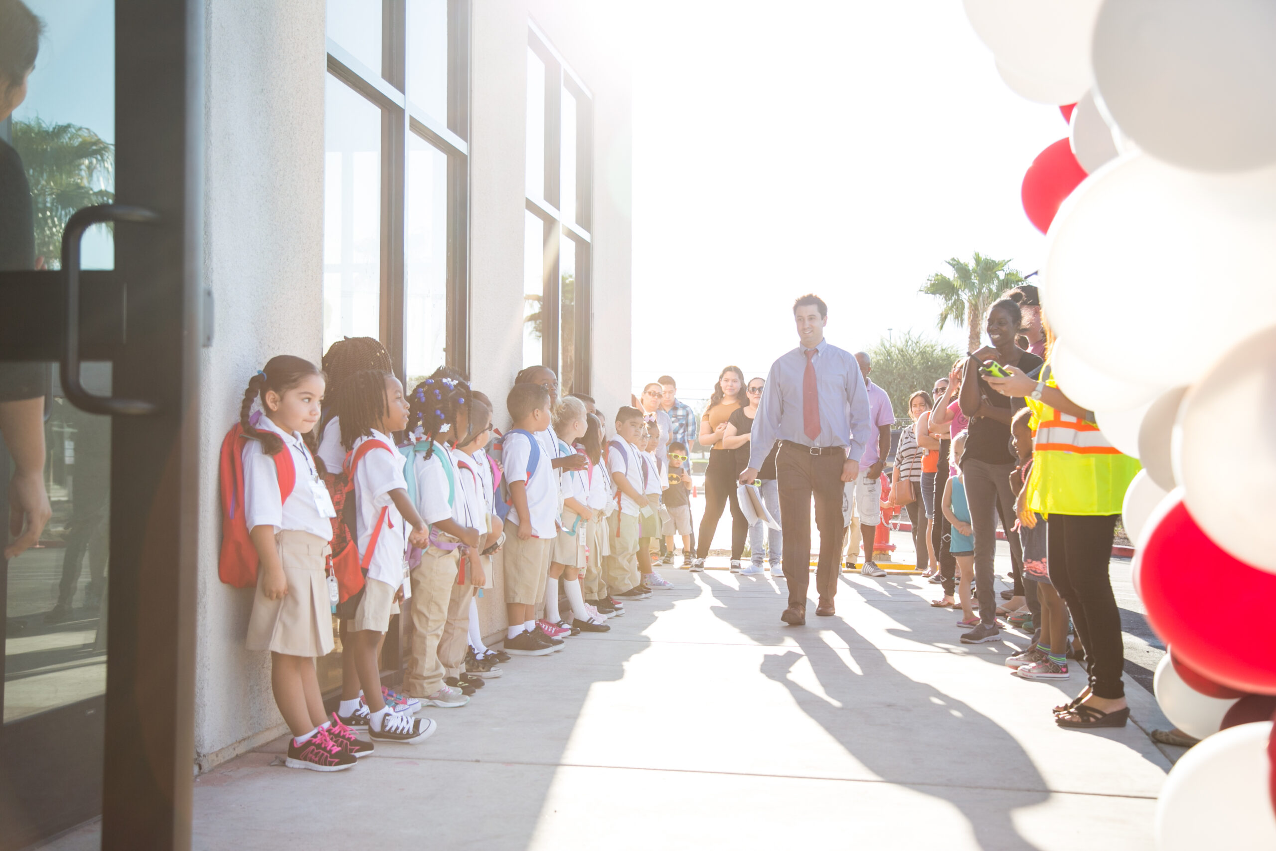 young students lined up on a wall waiting for teacher to walk by