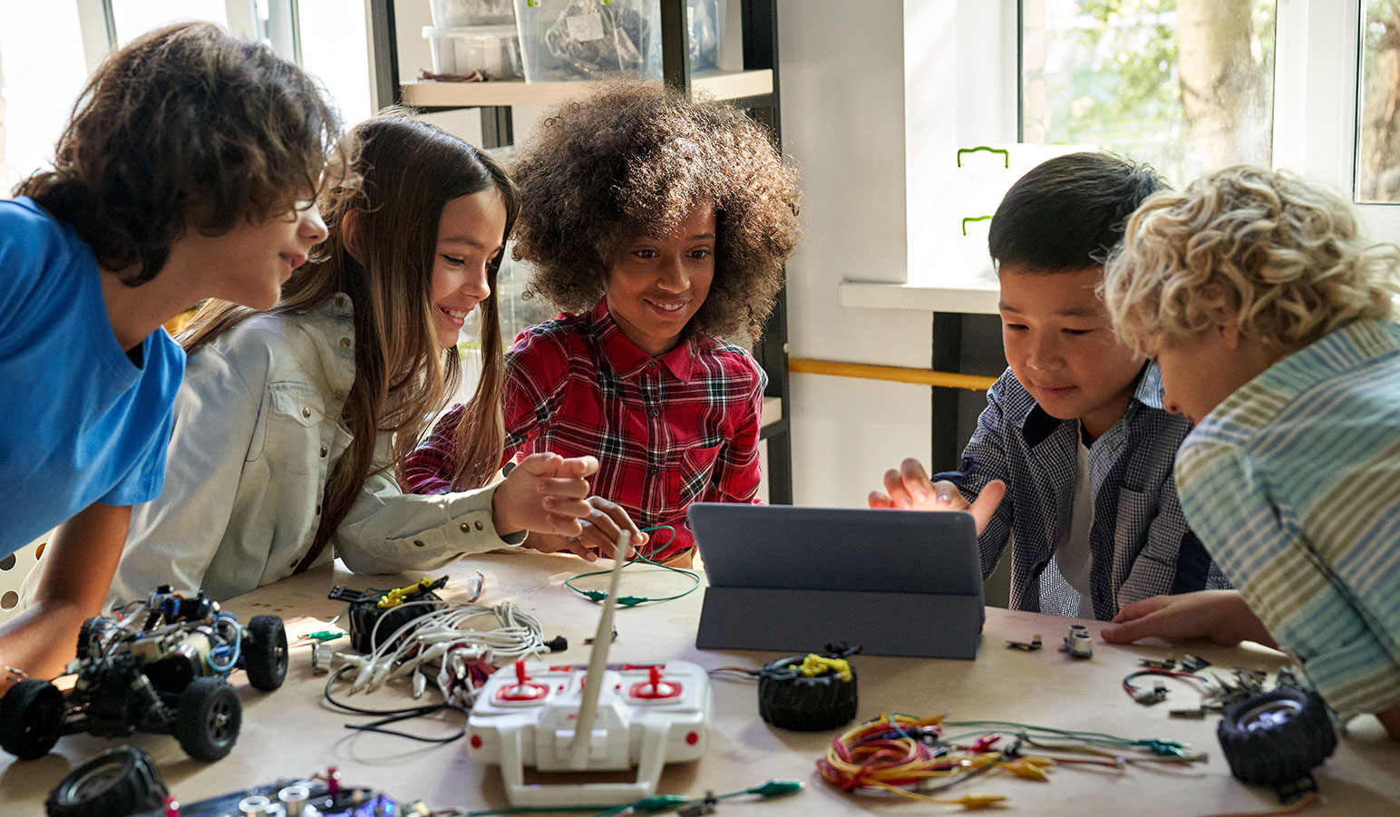 Group of students at a table working on a remote controlled car