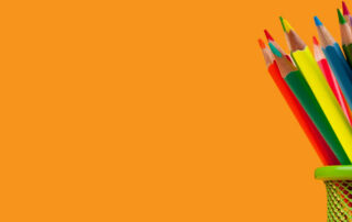 Colored pencils over an orange background