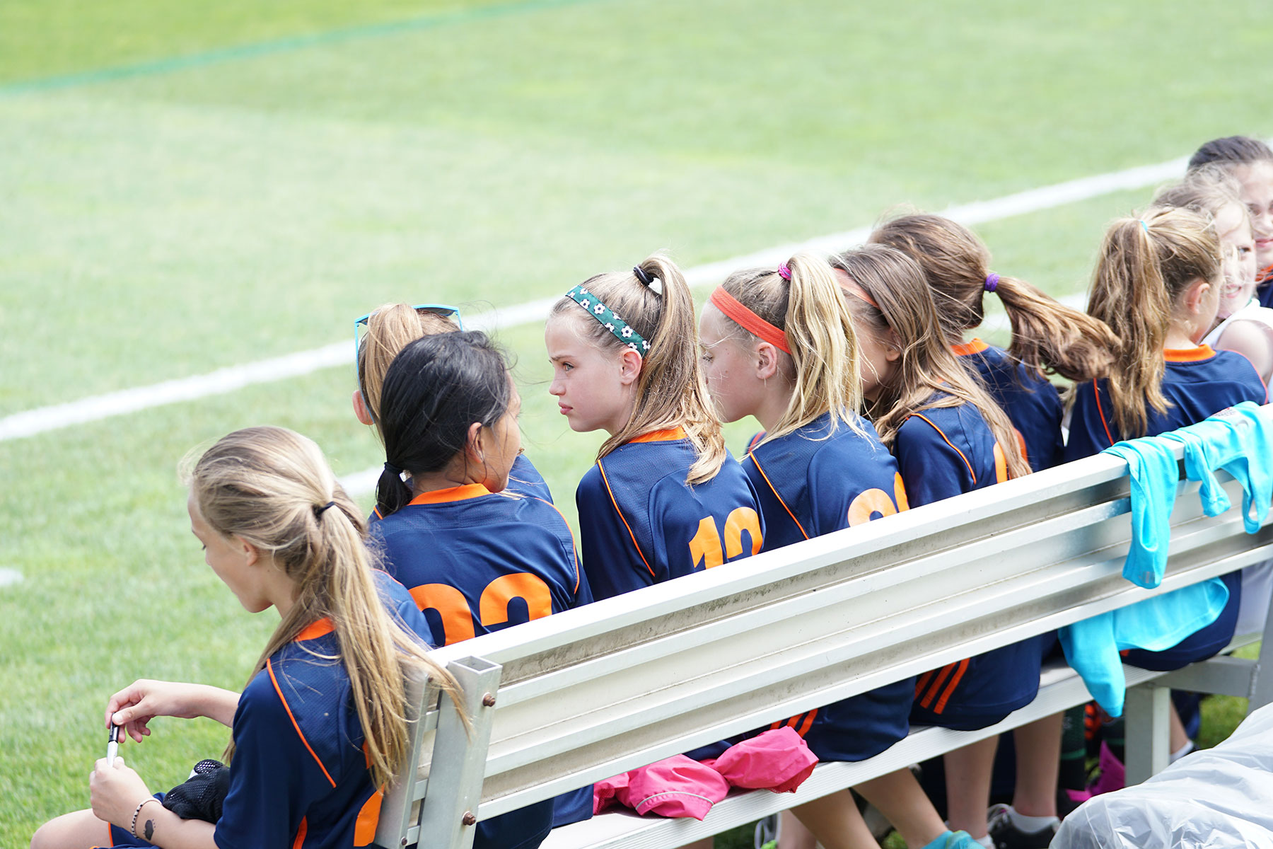 An elementary school girl's soccer team sitting on a bench