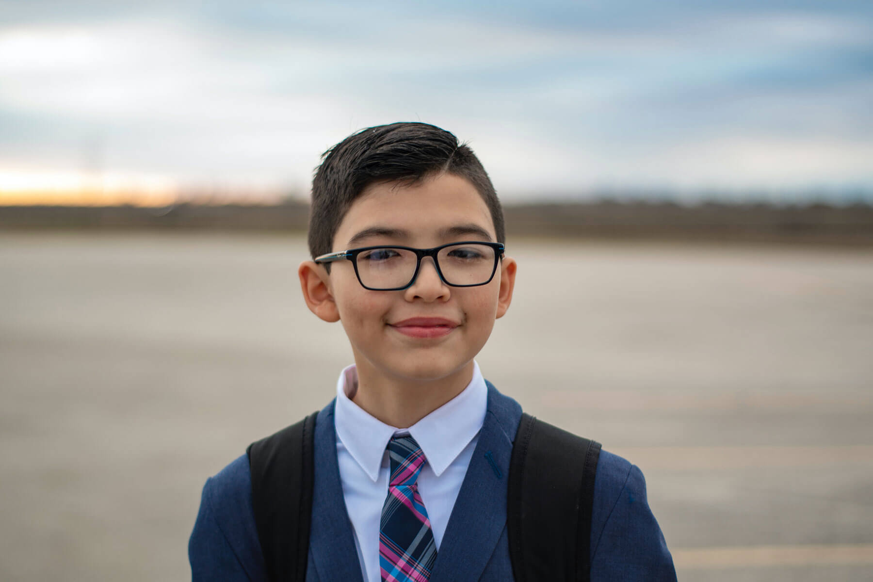 young boy in uniform smiling at the camera