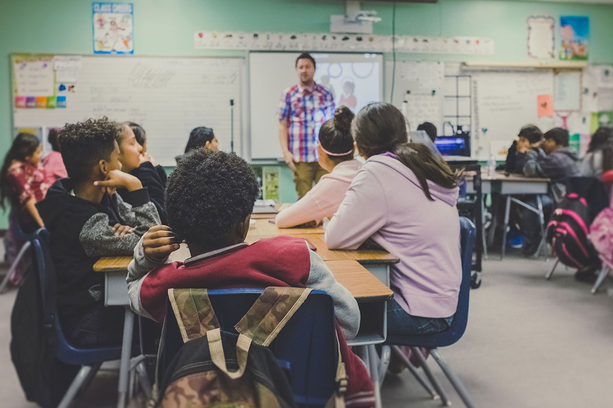 Group of students in classroom looking at teacher