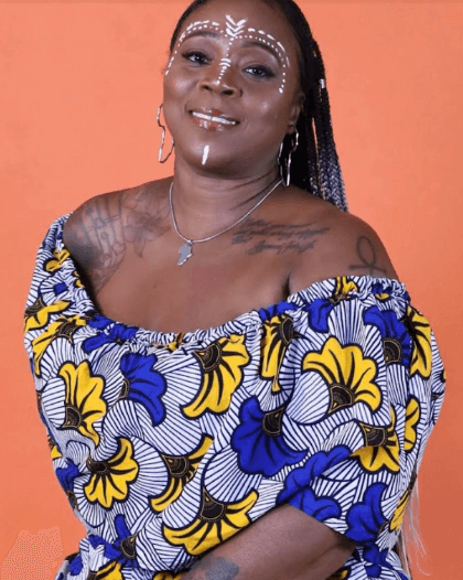 Akiko-Ayalla Cooks Woman in purple dress with orange background